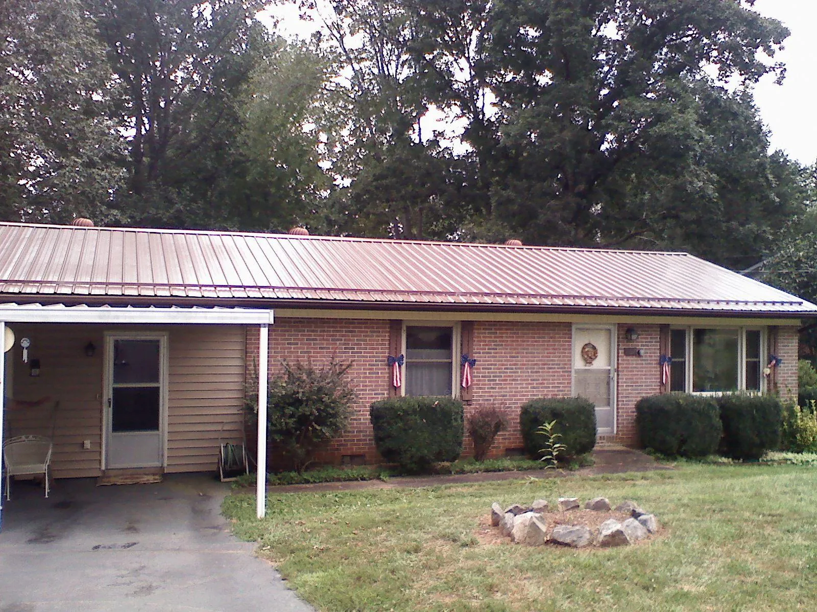 Bronze metal roof and carport on a brick ranch home — Roof Repair work by our crew in Mc Clure