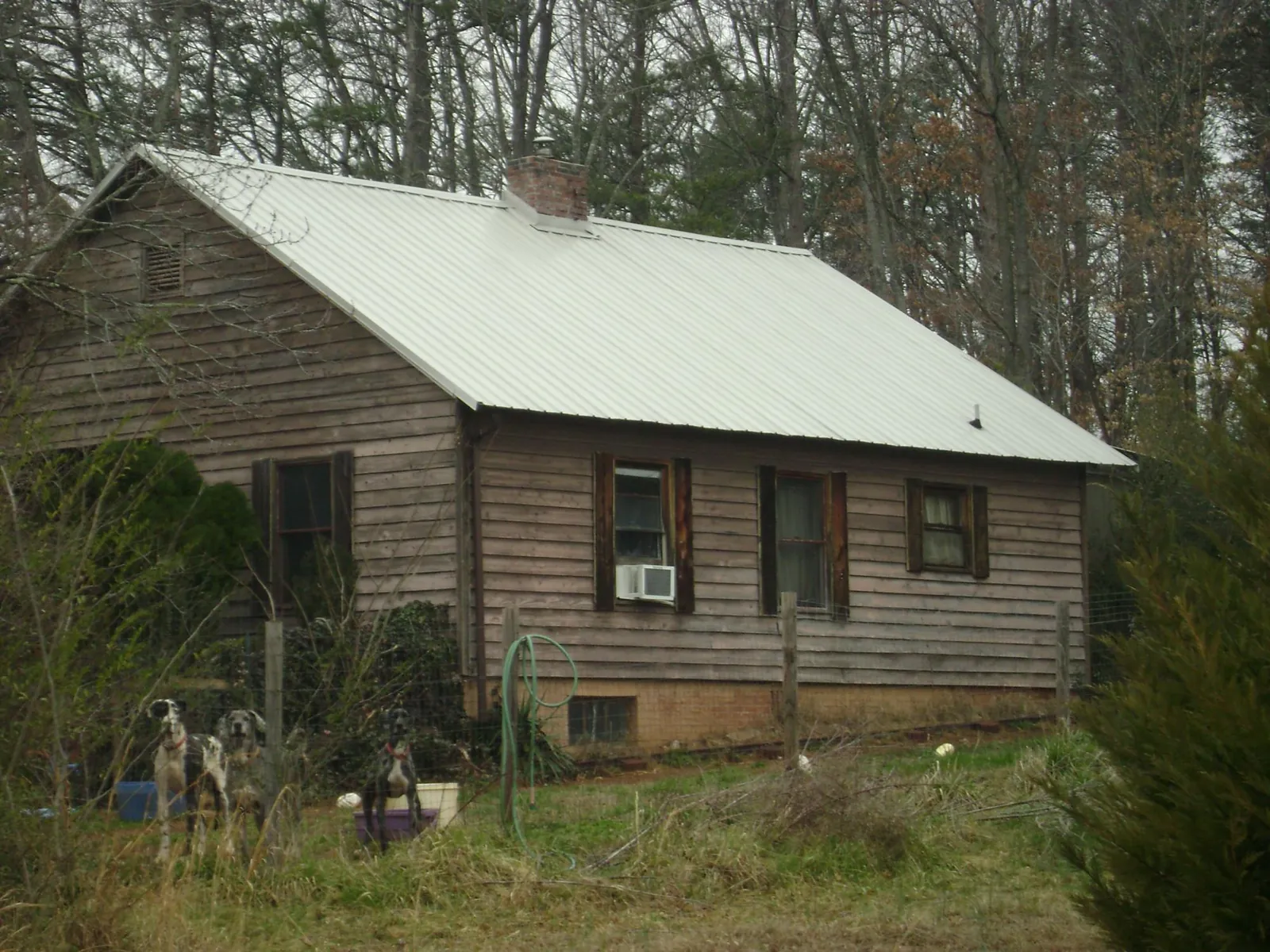 White metal roof on an old wood sided farmhouse, from a Metal Roof Installation job in Mc Clure